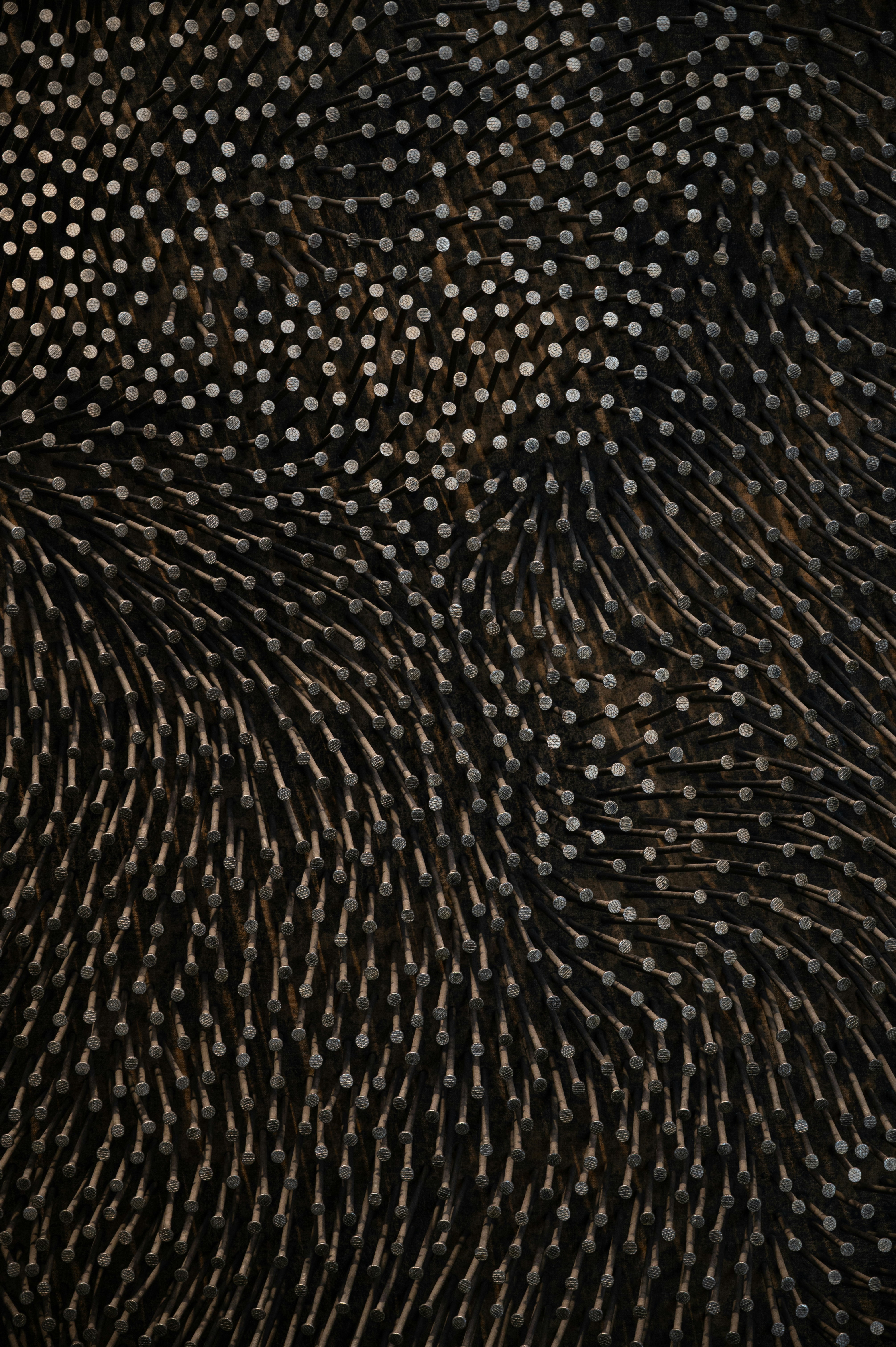 nails hammered into a dark wavy pattern